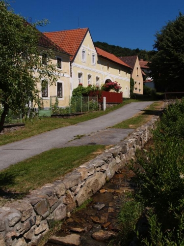 Vodická náves je upravená, stejně tak potůček protékající vesnicí.