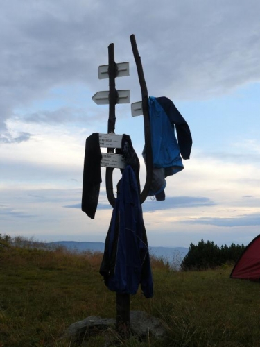 Z rozcestník je věšák, ale ani ten nestačí, takže věcmi jsme obložili také malou skalku kousek od stanu.