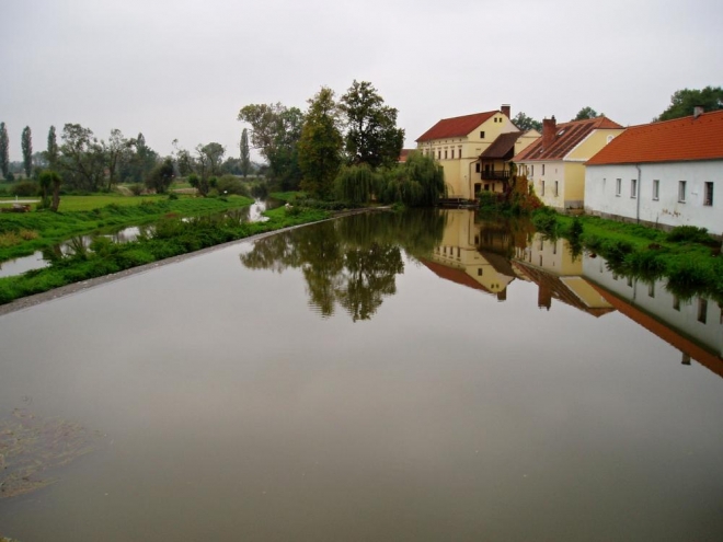 Pohled na klidnou vodu nad jezem.