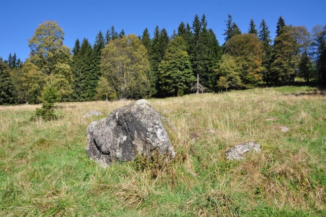 První zatoulaný kámen zvěstuje skalní bloky kdesi nahoře nad našimi hlavami. 