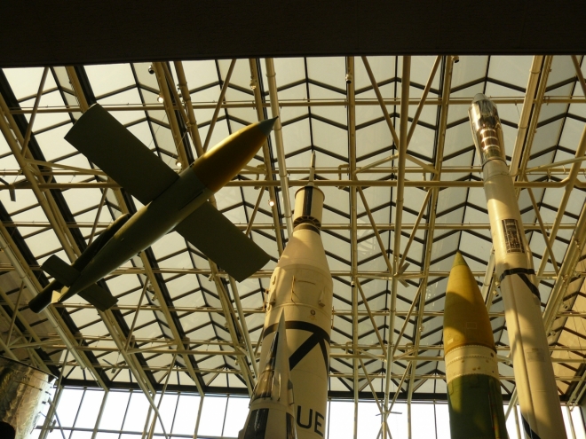 Pohled ke stropu muzea na špičky raket.