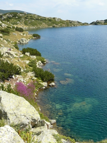 Značka obcházející jezero vede nahoru a dolů po kamenech a nabízí rozmanité pohledy na pobřeží.