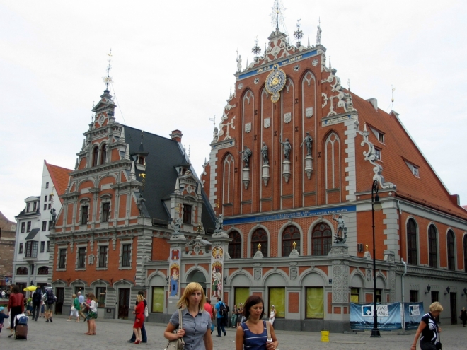 Tyto dva domy jsou spolu s radnicí hlavní dominantou náměstí. Dům Černohlavců (Melngalvju nams) zde stával již od 14. století, dokud jej nezničily německé bomby v roce 1941 a sovětská demolice v roce 1948, současná stavba (vpravo) je tak pouze od základu provedenou, byť zdařilou rekonstrukcí z konce tisíciletí. Podobný osud postihl i sousední Švábský dům s tím rozdílem, že tento byl prvně vybudován až na konci století devatenáctého.