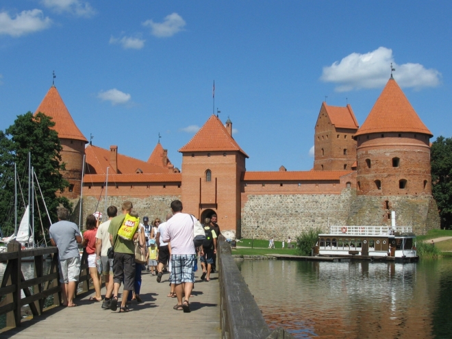 Vracíme se zpátky na tradiční turistickou cestu, která je dost přelidněná. Směrem k hradu je třeba přejít dvojici mostů. Na ostrůvku mezi nimi zcela regulérně žebrá parta dětí s hudebními nástroji o peníze, to jsme v Pobaltí dosud neviděli.