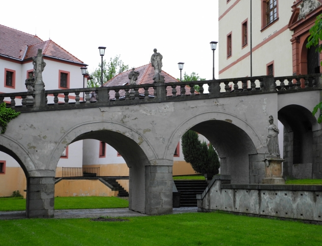 Bývalý dřevěný padací most k Novému zámku byl kolem poloviny 18. století stržen a vybudoval se nový kamenný most, který zdobí sochy 6 světců - sv. Václava, sv. Barbory, sv. Jena Nepomuckého, sv. Vavřince, sv. Šebestiána a sv. Víta.