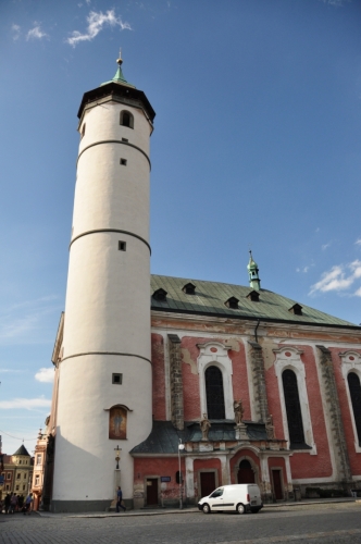Kostel Narození Panny Marie s válcovitou věží, která původně ke kostelu nenáležela a bývala hláskou, je dominantou náměstí. První zmínky o kostele se datují k roku 1385, ale pozdější zprávy udávají rok založení 1111. Toto datum je také vepsáno na klenebním oblouku nad kruchtou. Z původní gotické stavby zůstaly zachovány křížové klenby boční lodi a profilované portály. Po požáru města roku 1747 byl kostel v letech 1751-56 barokně přestavěn. Klenutí chrámové lodi je zdobeno freskami F. J. Luxe z roku 1756. Mezi skvosty náleží oltář Narození Panny Marie, dílo pražských mistrů. Ve věži je kromě zvonů Zikmund, Poledník, Hodinka umístěn na ochozu zvonek &quot;Advent&quot; u 15. století, na který se zvoní v předvánočním období.