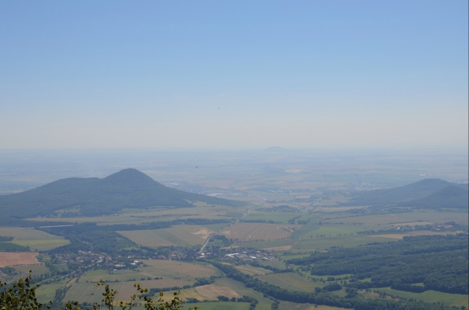 Na jihovýchod je paradoxně lepší výhled zpod rozhledny. Vlevo již známý Lovoš, vpravo by měly být v zákrytu Boreč (449 m) a Ovčín (431 m), v dálce uprostřed pak sotva viditelný Říp.