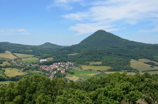 Milešov a Milešovka. Díky kamenným kobercům nepřekáží ve výhledu les, takže se dá dobře fotit okolní krajina, chce to jen neskutálet se dolů.