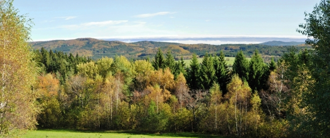 Nad Kuklovem jsou podzimně zabarvené vrchy Šibeníku (787 m n. m.)a Vlčího kopce (767 m n. m.), které patří do CHKO Blanský les.