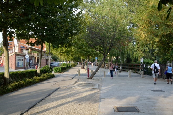Po zhruba kilometru přecházíme na promenádu, stále držíme stejný směr. Míjíme dlouhou řadu obchodů, stánků, restaurací, a také další ubytovací zařízení.