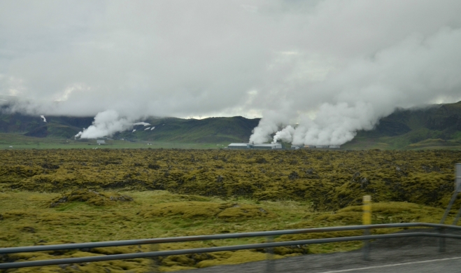 Cestou z autobusu pozorujeme lávová pole a za nimi (zřejmě) geotermální elektrárny.