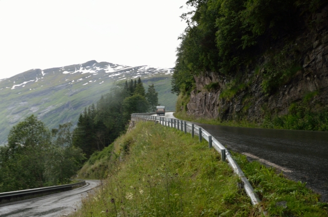 Vzhledem k množství turistů a nevlídnému počasí se na vyhlídce nezdržujeme dlouho. Nyní sjíždíme do vesnice Geiranger. Cestou nás pronásleduje šílený smrad z brzd, naštěstí ne našich, a ohrožuje pár švédských seniorů názorně předvádějící, jak se nemá řídit auto (dvacítkou po prostředku a tak dále). Časem se ho Michalovi naštěstí podaří předjet.