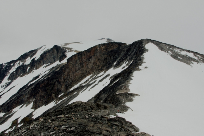 Po zdolání Svellnose je před námi krátké klesání a výstup na další vrcholovou prémii – Keilhaus topp (2355 m n. m.). V pozadí se nám již začíná ukazovat samotný vrchol Galdhøpiggenu. Velké převýšení budilo na papíře respekt, ale zatím ho zvládáme dobře, to nejhorší už máme za sebou.