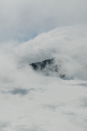 Jeden z blízkých vrcholů v sevření bílých oblak. Na každého nadšeného fotografa tu dnes čeká spousta příležitostí se vyřádit.