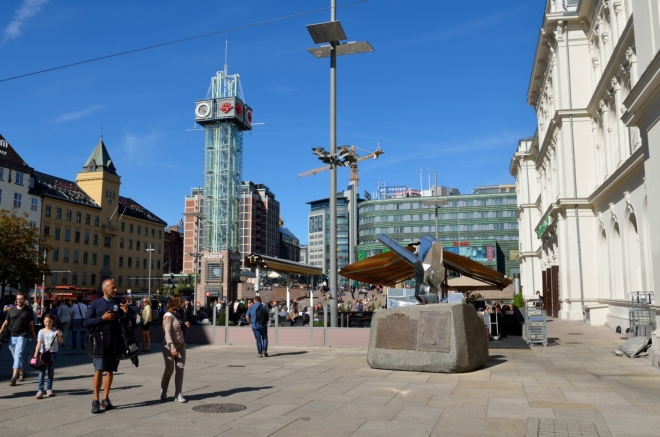 Prostranství před nádražím. Znovu zde potkáváme spoustu lidí nenorského původu, a to nejen mezi turisty – ze zhruba 650 tisíc obyvatel Osla, jež v posledních letech překotně roste, je zhruba každý třetí původem z ciziny či přímým potomkem imigrantů.