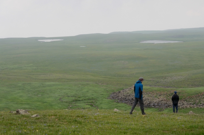 Zahazujeme batohy a trochu se rozhlížíme. Před námi se rozkládá velká planina s jezery a tábory pastevců.