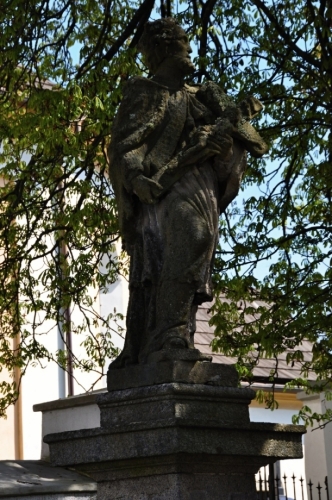 Socha sv. Nepomuka před kostelem.