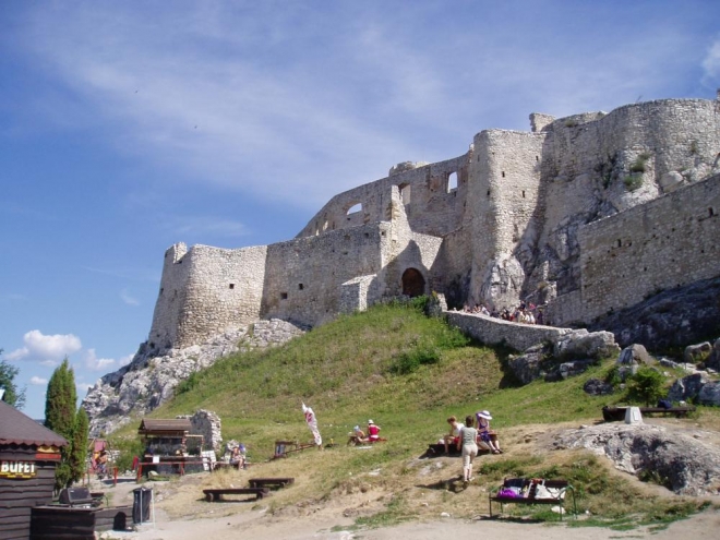 Uvnitř strávíme docela dost času jeho prohlídkou.  SPIŠSKÝ HRAD  Spišský hradný vrch je unikátnym územím. Už neolitickí ľudia tu po sebe zanechali stopy dnes staré takmer 7 tisíc rokov. Ešte oveľa skôr sa týmito končinami pohyboval i neandertálsky človek. V jaskyni pod hradom boli nedávno nájdené kostrové ostatky muža a pri nich kožené mešce aj s mincami takmer spred dvetisíc rokov, z čias keltských Kotínov. Pred viac ako 800 rokmi tu začal vyrastať mohutný kamenný hrad v nadmorskej výške 634 m. No v roku 1780 sa na ňom nezmazateľne podpísal požiar. Hradná ruina spolu s rovnako jedinečným okolím územia Spiš je od roku 1993 súčasťou Svetového kultúrneho a prírodného dedičstva UNESCO.  Prvé, čo pred 800 rokmi na vysokom brale vzklíčilo, bola mohutná obranná a zároveň obytná veža donžon. Prsty v tom mal kráľ Belo III. Možno kráľovná. Postavili ju zo spišského travertínu. Zakrátko sa však zrútila. Asi kvôli tektonickým posunom v podloží. I dnes sa s kopcom dejú divy. Do nového opevneného celku sa už vstupovalo románskou bránou s padacou mrežou a smolným nosom. Vo vnútri vyrástol románsky palác a nová veža, veža Nebojsa. Či  sa v nej skutočne ani raz nemuseli báť, zachované pramene neprezrádzajú.  Tatárom nemusel odolávať. Boli vlastne na Spiši? Dnes už nikto nevie a aj keby boli, hrad ich nezaujímal. Zdá sa, že už krátko na to získal dnešnú dych vyrážajúcu rozlohu v podobe dvoch samostatných opevnených celkov. Zaujal spišského prepošta, ktorý sa zaviazal kráľovi o hrad sa starať a ten mu na oplátku udelil privilégium na hrade žiť. Veď, čo ak by tí nomádi prišli naozaj. Pred vstupom do horného hradu si nechal vystavať vlastnú časť. Celé predhradie s obytnou vežou, z ktorej sa dalo ochodzou dostať do románskej kaplnky. Tu nechal postaviť rovno pod nosom špána, kráľovského správcu Spiša, obývajúceho románsky palác na hradnej akropole. 