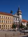 Jeden z nejkrásnějších domů na náměstí, Sitrův dům, má starší, gotické základy. Nejvýznamnější přestavba byla provedena v roce 1604, kdy byl dům v majetku Tomáše Sitra. Při výzdobě domu se prachatický malíř Šebastián Hájek zřejmě nechal z části inspirovat podobou tehdy nové renesanční radnice. Pod lunetovou římsou se nachází portrétní galerie deseti českých králů (od Václava Rožmberka, latinský nápis nad vchodem do brány praví: "Pověst odmění veliké námahy. Po smrti poroste sláva Rožmberků. Tato ozdoba potrvá na věky".     U vjezdu jsou patrny kladky, po nichž se vedly řetězy padacího mostu. Otvorem v první části brány bylo možno spustit ochrannou mříž. Kamenné dělové koule v průčelí brány, které údajně použili husité v čele s Janem Žižkou při dobývání města v roce 1420, byly na místo zazděny dodatečně.