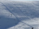 Nízké zimní slunce osvětlovalo sníh zvedaný lyžaři na chvilku do vzduchu, jen aby se blýskl svou krásou.