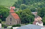 Hřbitovní kostel U Svatých leží při severovýchodním okraji města. Starobylý gotický kostel byl vystavěn v polovině 14. století. Archivní doklad města popisuje, že v roce 1648 úderem blesku a vzniklým požárem byl značně poškozen a ztratil gotickou klenbu lodi. Všechny stavební práce byly dokončeny na tomto kostele až roku 1920. Uvnitř kostela je kamenná renesanční kazatelna a v lodi kostela je umístěno u zdi 15 náhrobních kamenů význačných osobností města. V těchto místech stával do 18. století také kostel sv. Jakuba o němž jsou první zmínky z roku 1037, kdy byl knížetem Břetislavem I. věnován benediktinskému klášteru v Ostrově. Toto darování potvrdil i český král Přemysl Otakar I. r. 1205 a český král Václav IV. r. 1399. Po roce 1406 byly do něho přeloženy všechny bhoslužby. Koncem 18.století kostel sv. Jakuba značně zchátral, byl odsvěcen a prodán r. 1788 domažlickému měšťanu, tkalci Václavu Hájkovi. Vzápětí byl zbourán a dnes po něm není památky. (viz www.domazlice.cz)