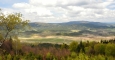 V popředí Mlýnské vrchy Kraví vrch, vlevo vzadu masí Kleti.