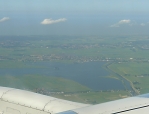 Z letadla Do Amsterdamu se kochám pohledy na rovinaté holandské pobřeží se spoustou kanálů.