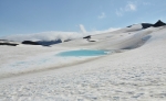 Nezamrzlé tyrkysově modré jezero uprostřed sněhu vypadá dosti neobvykle. Zřejmě se pod ním nachází nějaký ten termální pramen.