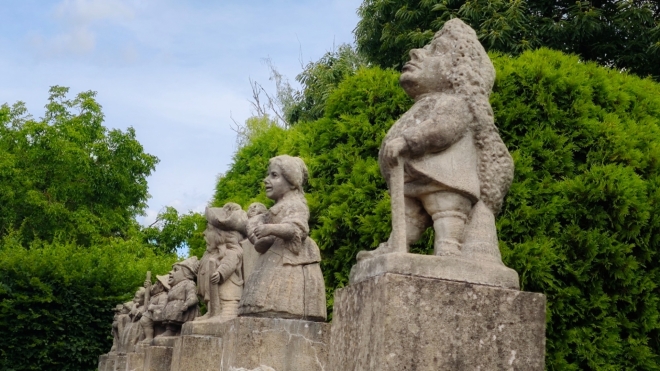 Kamenní trpaslíci ztvárňující karikatury lidského charakteru vznikly kolem r. 1713 v dílně významného barokního sochaře Matyáše Brauna. Do areálu novoměstského zámku bylo zakoupeno 24 sošek v r. 1929, později byly použity k výzdobě dolní zámecké zahrady. Originály jsou dnes uchovány v zámeckém depozitáři, zahradu zdobí věrné kopie. (Mapa.com)